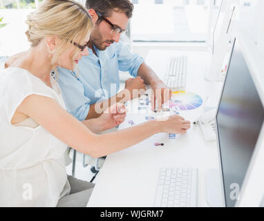Side view of photo editors working on computers in a bright office Stock Photo