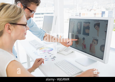 Side view of photo editors working on computer in a bright office Stock Photo