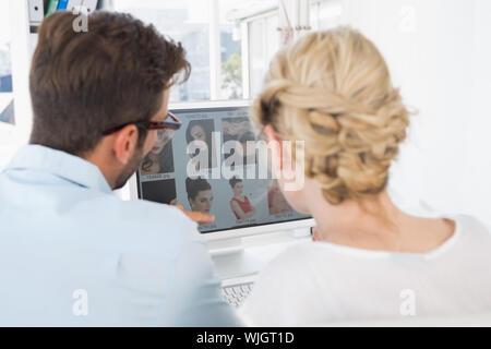 Rear view of photo editors working on computer in a bright office Stock Photo