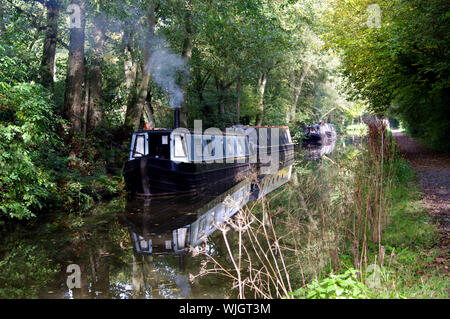 Narrow boats on the canal with chimneys blowing smoke Stock Photo