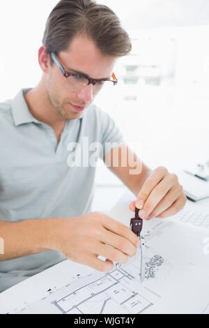 Concentrated young man using compass on design Stock Photo