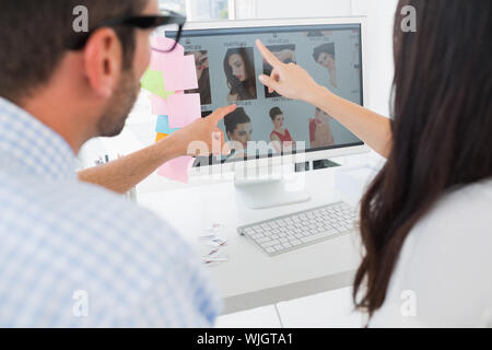 Rear view of casual photo editors working on computer in a bright office Stock Photo