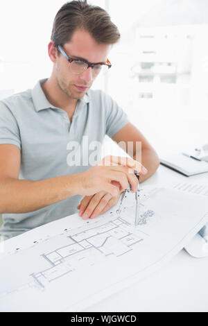 Concentrated young man using compass on design Stock Photo