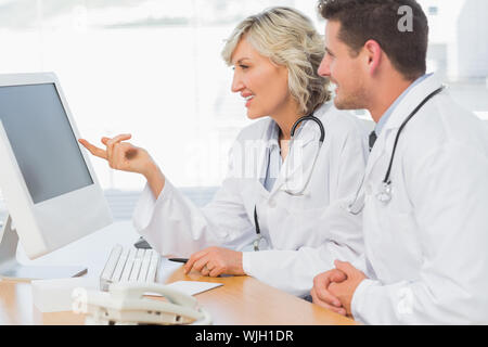Two concentrated doctors using computer at medical office Stock Photo