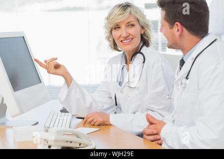 Two concentrated doctors using computer at medical office Stock Photo