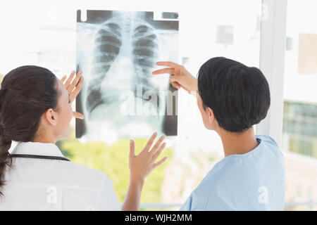 Rear view of two female doctors examining x-ray in the medical office Stock Photo