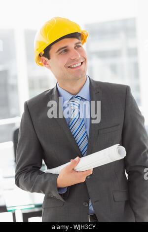 Happy architect smiling and holding blueprints in the office Stock Photo