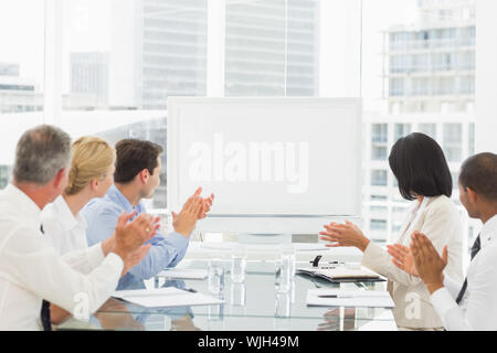 Business people applauding blank whiteboard in conference room in the office Stock Photo