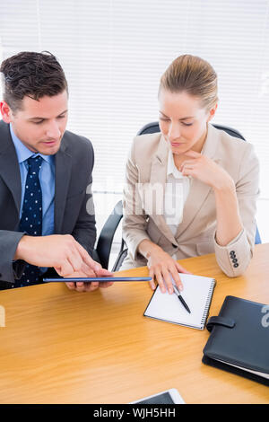 Smartly dressed young man and woman in a business meeting at office desk Stock Photo