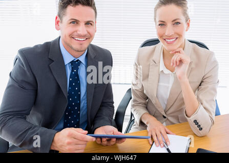 Portrait of a smartly dressed young man and woman in a business meeting at office desk Stock Photo