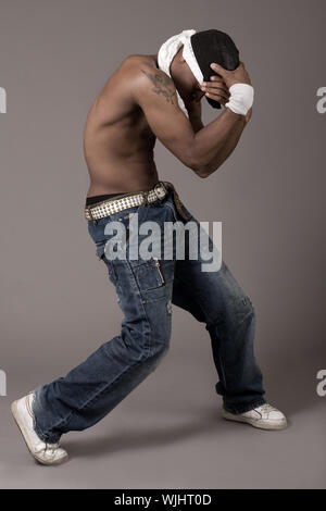 Young teenager performing dance movements on grey background Stock Photo
