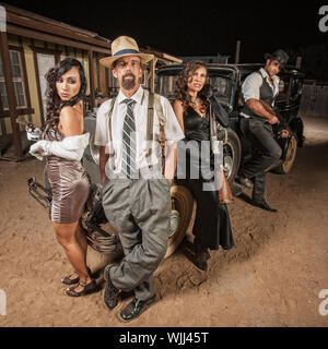 Gangster with hands in pockets next to partners in crime Stock Photo