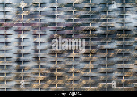 Old black and brown metal wall background. Horisontal and vertical lines gate. City or rural rtexture. Dark geometric wallpaper Stock Photo