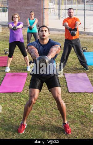 Strong man with tattoo leading kettle bell weight training Stock Photo