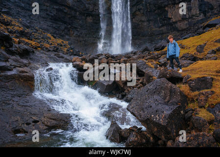 Tourist at the Fossa Waterfall on island Bordoy in the Faroe Islands Stock Photo