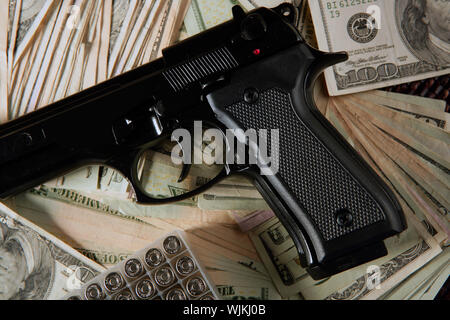 Dollar notes and gun, black pistol, mafia inspiration Stock Photo