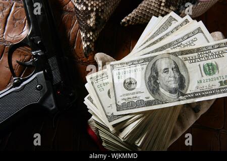 Dollar notes and gun, black pistol, mafia inspiration Stock Photo