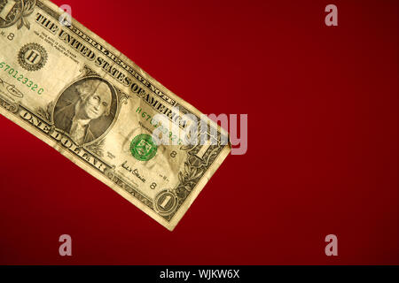 One dollar note over red background, studio crop shot Stock Photo