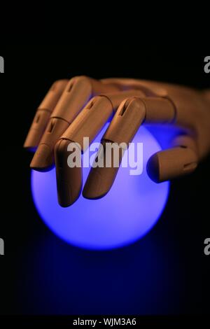 Wooden mannequin hand, ball of light, fortune teller, adivination Stock Photo