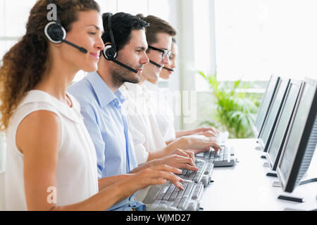 Call center operators working at desk in office Stock Photo