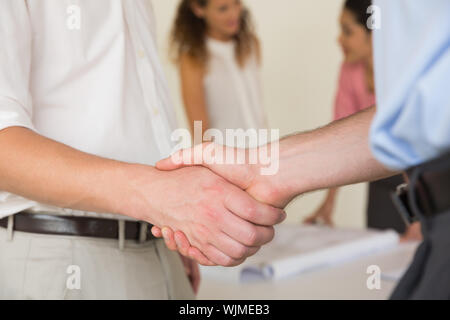 Mid section of business people shaking hands in office meeting Stock Photo