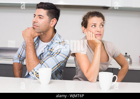 Unhappy couple having coffee not speaking at home in kitchen Stock Photo