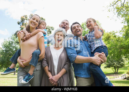 Portrait of cheerful extended family standing at the park Stock Photo