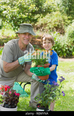 Portrait of a smiling grandfather and grandson engaged in gardening Stock Photo