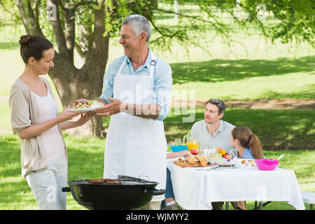 View of an extended family having lunch in the lawn Stock Photo