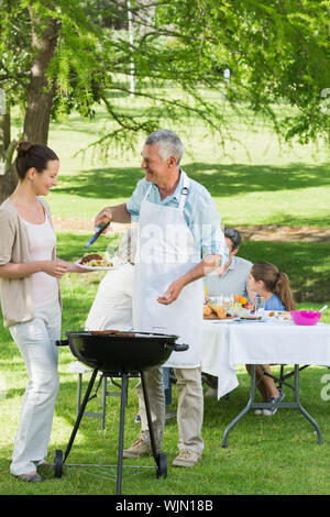 View of an extended family having lunch in the lawn Stock Photo