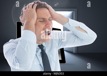 Stressed businessman with hands on head against doors opening revealing light Stock Photo