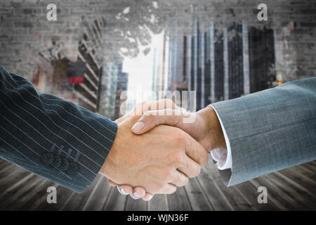 Composite image of business handshake against light shining into dark room Stock Photo