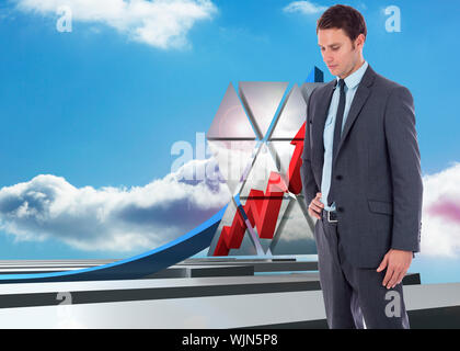Serious businessman with hand on hip against blue curved arrow pointing up against sky Stock Photo