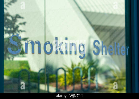 Smoking Shelter sign at designated outdoor smoking area where cigarette smokers can relax and smoke without breaking any anti-smoking laws or regulati Stock Photo