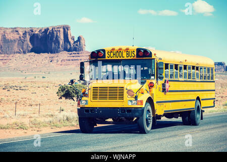 school bus traveling near Monument Valley Stock Photo