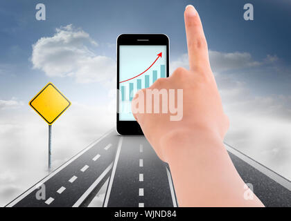 Female hand pointing against road over clouds with road signs on it Stock Photo