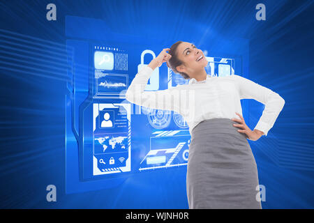 Smiling thoughtful businesswoman against shiny cogs on blue background Stock Photo