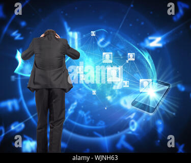 Stressed businessman with hands on head against blue background with letters Stock Photo