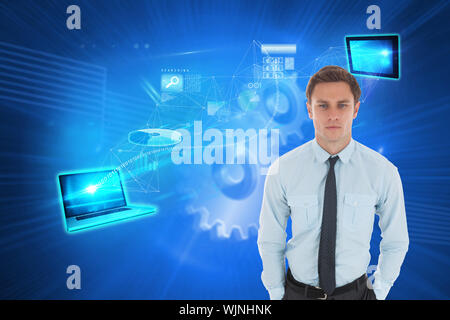 Serious businessman with hands in pockets against shiny cogs on blue background Stock Photo