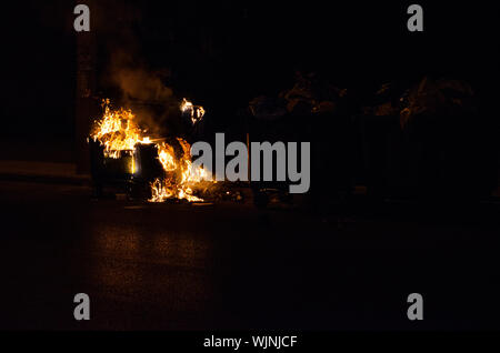 Athens,Menidi /Greece August 28 2019: Night outdoor Fireman extinguish fire garbage bin Stock Photo