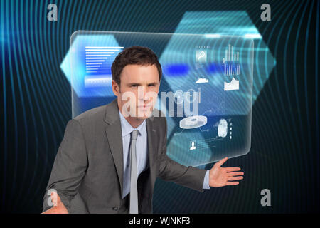 Businessman posing with hands out against shiny hexagons on black background Stock Photo