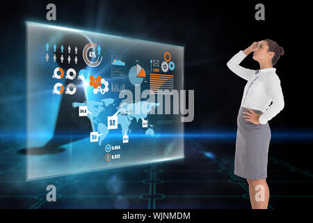 Focused businesswoman against keyhole on technological black background Stock Photo