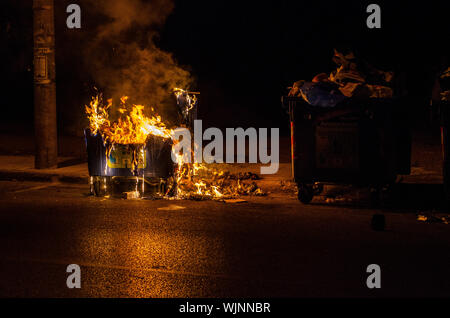 Athens,Menidi /Greece August 28 2019: Night outdoor Fireman extinguish fire garbage bin Stock Photo