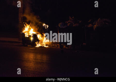 Athens,Menidi /Greece August 28 2019: Night outdoor Fireman extinguish fire garbage bin Stock Photo