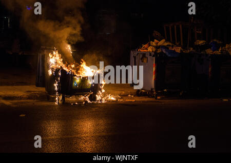 Athens,Menidi /Greece August 28 2019: Night outdoor Fireman extinguish fire garbage bin Stock Photo