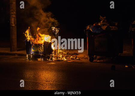 Athens,Menidi /Greece August 28 2019: Night outdoor Fireman extinguish fire garbage bin Stock Photo