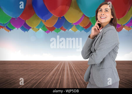 Happy businesswoman against many colourful balloons sky background Stock Photo