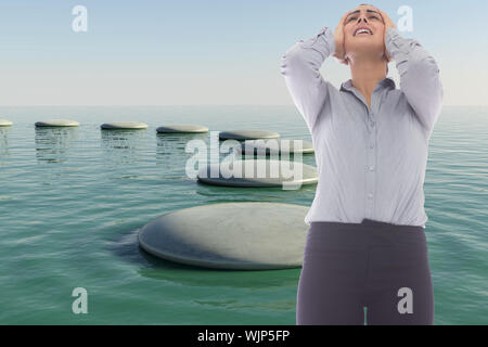 Desperate businesswoman against zen rock pool Stock Photo