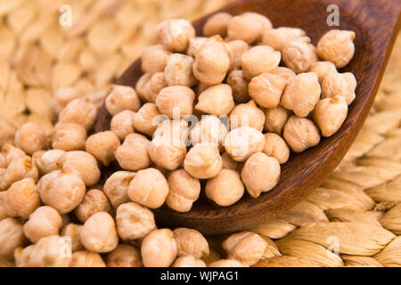 dried white chickpeas ceci on the wooden spoon Stock Photo