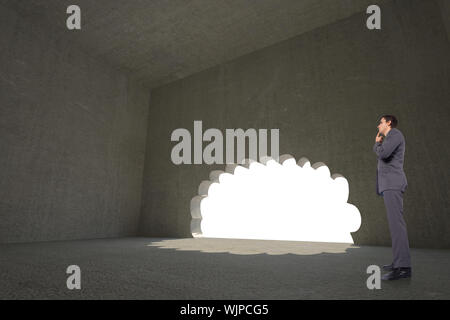 Thinking businessman with hand on chin against cloud shaped door in dark room Stock Photo